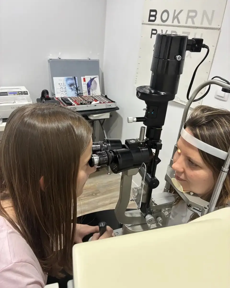 Une opticienne observe l'œil d'une personne à la lampe à fente